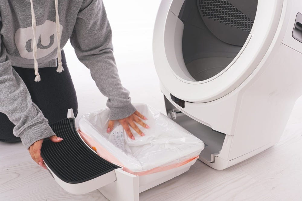 Smoothing the waste drawer liner and pushing the drawer closed